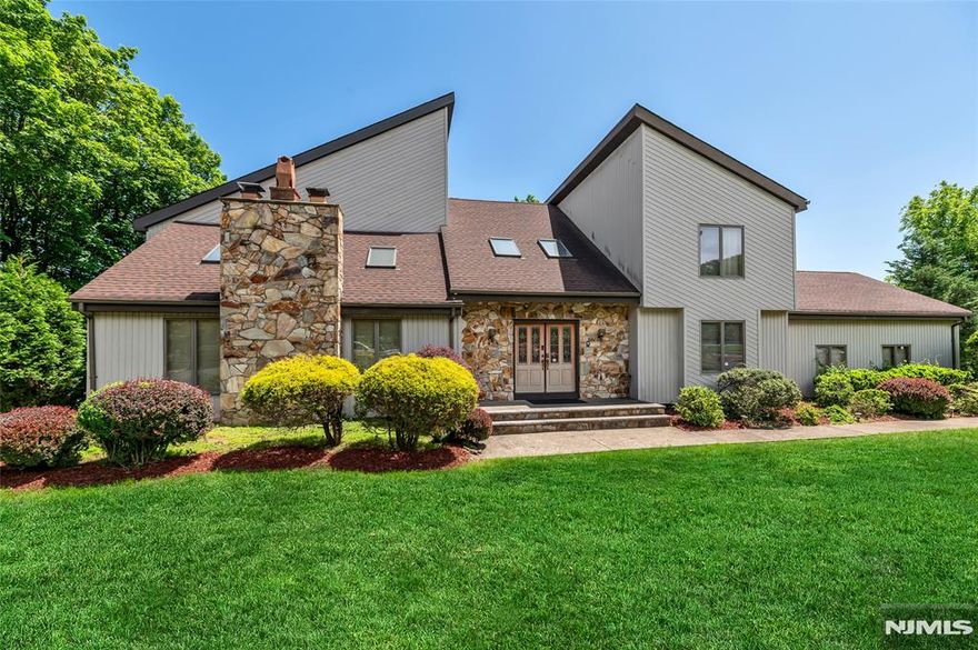 Escape to your own private retreat in Dey Hill Estates, this home offers exceptional privacy. 3,520 sq. ft. of living space + an additional 1,700 sq. ft. walk-out ground level, there's plenty of room to live, entertain, & relax. The neighborhood is quiet & inviting perfect for evening strolls & taking in the beautiful views. You'll find a modern design with an open layout, highlighted by a grand foyer that flows seamlessly into an expansive great room, creating a welcoming atmosphere. Only minutes from NYC train/bus, major highways. Fall in love the moment you enter your sun-drenched great room w/ soaring cathedral ceilings, a dramatic stone fireplace, & an open floor plan. Vaulted ceilings throughout & seasonal skyline views of NYC, while gleaming hardwood floors. Oversized kitchen features a center island, tons of counter space, 2 pantries & endless storage. Your primary suite awaits with vaulted ceilings, a full wall of closets, & a spa-like bath boasting a soaking jacuzzi tub & walk-in shower. Generous size bedrooms w/ hardwood floors & deep closets. The versatile walk-out ground level w/ soaring ceilings fitted with a gym, game room, full bath, & 2 additional guest rooms. Transform the space into a wine cellar, home office, or additional bedrooms the choice is yours! Outside, enjoy 3 expansive new decks & lush tree-lined privacy. Oversized 2-car garage, NEW central AC, 4-zone heating, newer roof. This home provides privacy, space, & a welcoming neighborhood feel.