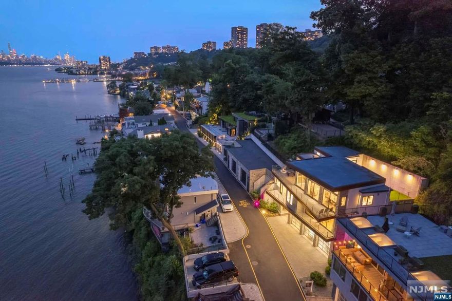 This is what you've been waiting for: A newer house in the coveted "Edgewater Colony" that has 4 bedrooms, a multi car garage, plus an elevator. This contemporary masterpiece was exquisitely designed w/dramatic features both inside & out. The floor to ceiling glass and high ceilings afford endless natural light and jaw dropping views of the Hudson River, GW Bridge, and Manhattan. Enjoy mid-town views from the DR & LR, and every bedroom, including the ground floor en-suite. The MBR is to die for w/a glass cat walk to the sleek white spa-like bathroom, and has a private balcony. It's great for downsizers and 'upsizers', who want a maintenance free property yet have unparalleled bucolic surroundings of the Palisades Park (bordered in back), with the parks entrance in front. It also an oversized garage (9'3"ft high doors) to fit the largest SUV's, w/2 EV car chargers. There's also a full back up generator & radiant heated floors throughout. "Curb appeal" is an understatement here.