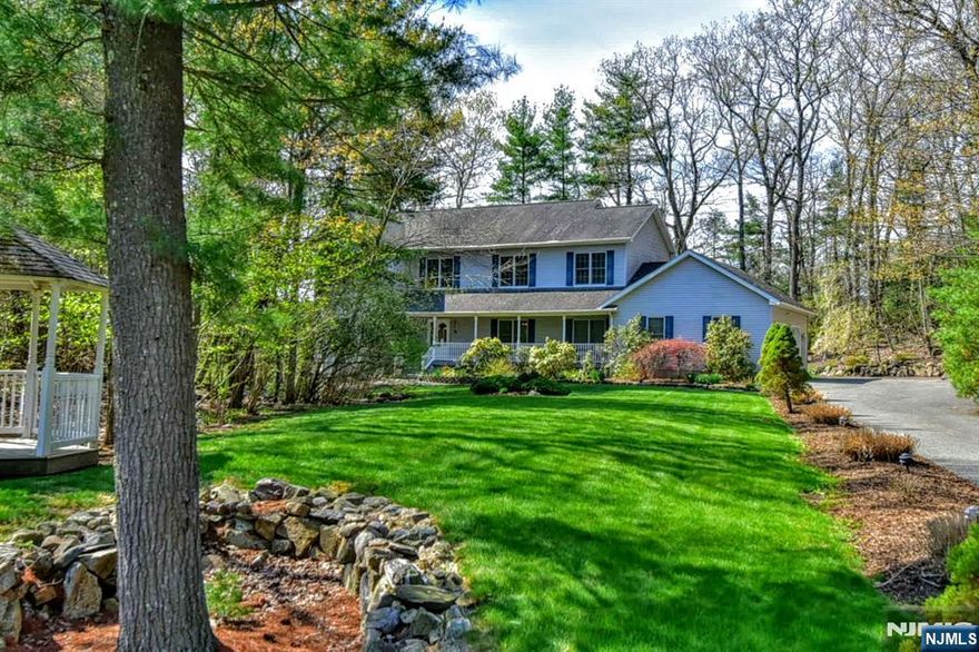 Magnificent Center Hall Colonial located in sought after Alpine Ridge Estates perfectly positioned at the end of a cul-de-sac. The residence is set far back on four private, wooded acres, offering an unmatched sense of seclusion and serenity. The exterior is a true nature lover's paradise. Relax on the charming rocking chair front porch or host gatherings on the huge rear deck. Inside the home unfolds with an effortless flow. The heart of the residence is the fabulous custom kitchen with center island and breakfast bar. This culinary space opens directly into a spacious family room with wood burning fireplace and formal dining room. The sanctuary of the home is the updated master suite with sitting area, soaking tub and walk-in shower. An additional three spacious bedrooms plus an office on upper level. The lower level offers additional space for games, movies, gym, workshop, etc.