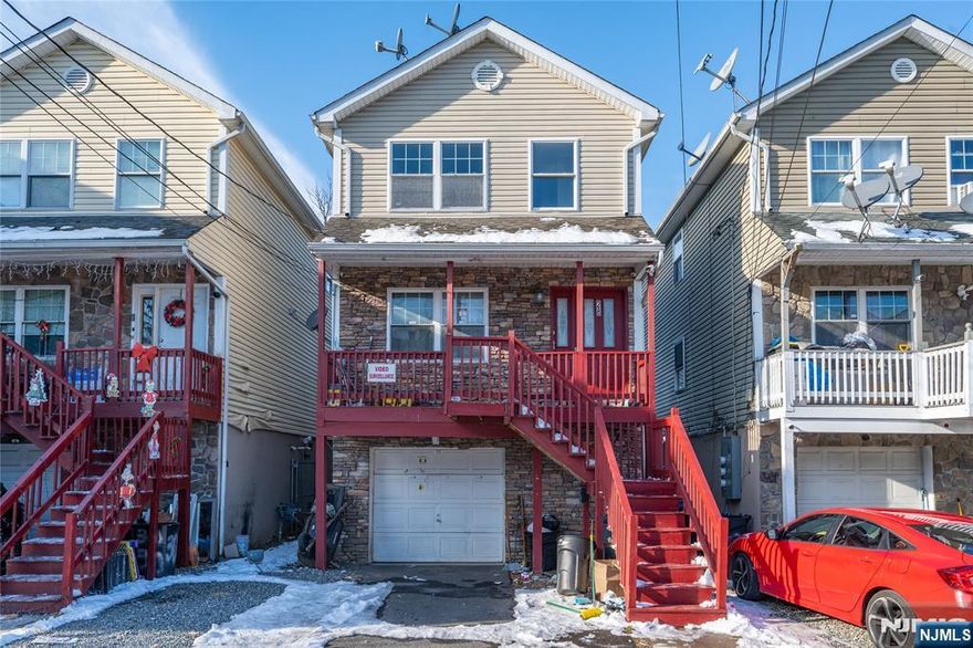 This well-kept two-family home makes a bold first impression. With its stone-accented front and elevated entrance, it offers a practical layout for both living and income. Each unit features 3 bedrooms, 2 full baths, an eat-in kitchen, a comfortable living room, and its own rear deck for outdoor space. Unit 1 also includes private access to the garage and a fully finished basement with an additional bathroom, laundry, and flexible space for storage or recreation. The property provides a one-car garage plus driveway parking for two more. Separate utilities for both units help simplify management and keep expenses straightforward. Located minutes from local shops, schools, restaurants, and the Broadway Bus Terminal with NYC access. The second unit will be delivered vacant, offering an immediate opportunity for a new lease or owner-occupancy. Don't miss it.