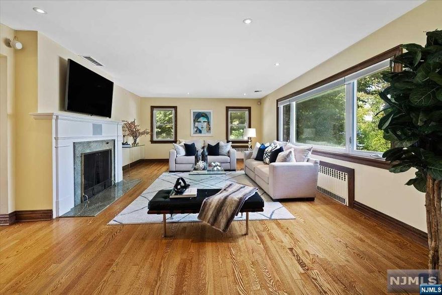 Welcome to 1025 Arcadian Way in Fort Lee. Nestled in the prestigious area The Bluff. A true gem, 5BR and 4baths. Luxury, privacy and accessibility are key words for this residence. Thoughtfully designed layout, the living room seamlessly connects to the dining room, leading you to the gourmet kitchen with top of the line appliances, including Subzero refrigerator, a Wolf stove and a wine cooler. A stunning sunroom with breathtaking views of the expansive backyard. The main level also features, an ensuite BR, 2 addl BR and a bath. On the 2nd level you'll find the main ensuite BR with a spa-like bath and a custom cedar closet. An addl versatile bedroom is located in this level. The garden level offers a spacious family room and a bath. Radiant floors in baths, kitchen & sun room. Ample storage closets, a laundry room and and a garage. Easy commute to NYC, close to schools, restaurants, movie theater and film Center. Make this exceptional home yours.