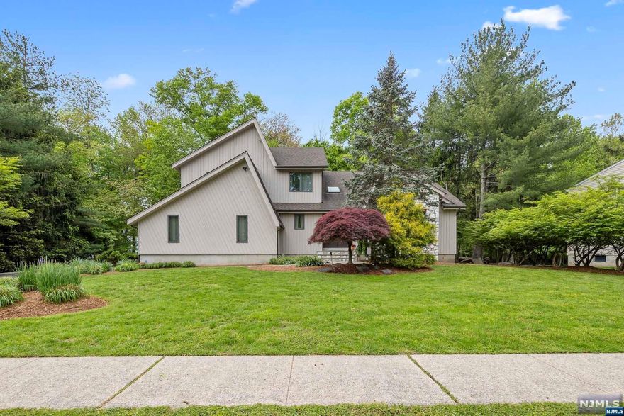 Stunning contemporary flooded by natural light with views of lush greenery from every window. The eat-in kitchen boasts large center island, granite countertops, upgraded cabinetry, and stainless-steel appliances, and flows into a cozy sunken family room with gas fireplace and sliding glass doors to deck. Two-story vaulted living room and sizeable dining room make this home perfect for entertaining. Music lovers can enjoy the house audio system. Homeowners can indulge in the generously sized primary bedroom and meticulously updated ensuite. Three additional bedrooms and newly renovated full bath offer ample space. Enjoy a movie or football game on a 120' screen in the finished basement. The music studio is the perfect space to practice an instrument!The VIRTUAL TOUR link for this listing contains a comprehensive video tour with hidden features & room dimensions, written description, additional photos, floor plans, and a complete interactive 3D model of the home.