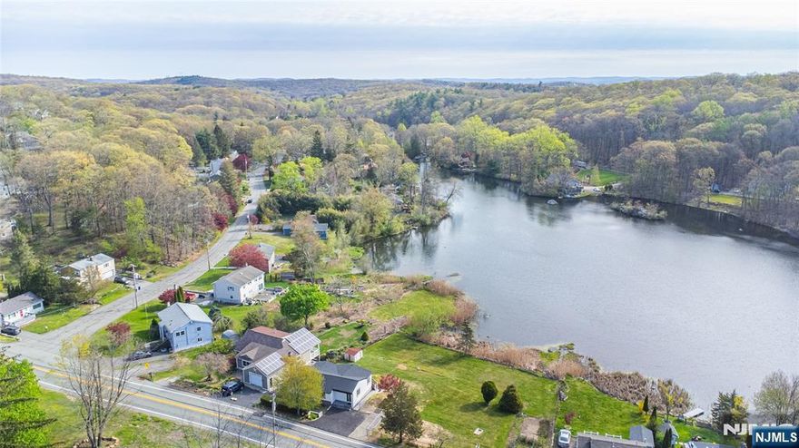 Welcome to this fully renovated lakefront gem in the desirable Mount Glen Lakes section of West Milford. Set on an oversized, level 0.40-acre lot with direct lake frontage and year-round water views, this 3-bedroom, 2-bath ranch offers the perfect blend of modern design and effortless one-level living. Completely redesigned in 2025, every detail has been thoughtfully updated for todayâ€™s lifestyle. Step inside to a bright, open living/dining area with beautiful wood floors and abundant natural light. Sliders off the living room lead to a deck overlooking the lake â€” the perfect place to relax or entertain while enjoying peaceful waterfront scenery in every season. The stunning new kitchen features sleek cabinetry, stylish countertops, and stainless steel appliances, including a gas range. One bedroom features its own private full bath, while two additional bedrooms share a second beautifully renovated bath. A convenient main-floor laundry closet is located in the hallway for easy access. The lower level offers excellent storage space and houses the utilities. With central air, natural gas heat, a blacktop driveway, lake privileges, and turnkey condition throughout, this is true one-level lake living at its finest.