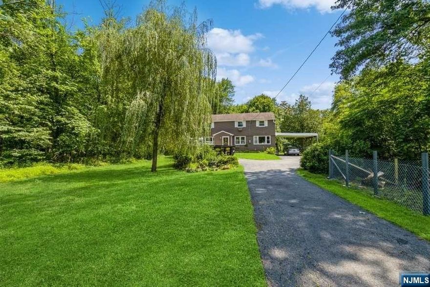 A private retreat with easy access to everything! Spacious four-bedroom, two-bathroom Colonial is set on approximately 1.5 acres of property in the northeast corner of Morris County. This home offers a peacefully situated haven in the foothills of Waughaw Mountain near Routes 287 and 23, shopping center, restaurants, parks, and schools. Set back from the road, a manicured front lawn and driveway bring you to a two-car carport and the front entryway. Step inside to the foyer opening to a large, bright living room. The dining area is attached to the kitchen and features stainless steel appliances, a breakfast bar, and a door to the large screened-in porch offering beautiful views of the sweeping back lawn and the woods beyond. There is a fenced in dog pen off the screened in porch with access to back and side yard. Off the kitchen is a pantry and an updated laundry room with a countertop and plenty of cabinets for storage.