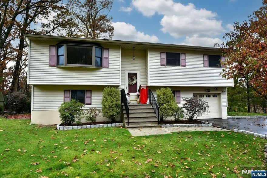 Welcome to this inviting 4-bedroom bi-level home in Ringwood! Nestled on a peaceful wooded lot, this home is sure to please. The main level features a bright and open living room with hardwood floors, a dining area ideal for gatherings, and a well-equipped kitchen with plenty of cabinet and counter space. Sliding glass doors off the kitchen lead to a large deck overlooking the serene backyard and side yard, perfect for outdoor entertaining or simply enjoying the tranquil surroundings. Down the hall are three spacious bedrooms and a full bath, all conveniently located on the main level. The ground floor offers even more flexibility with a large family room, a fourth bedroom ideal for guests, an office, or extended living, and a combined laundry room, half bath and utility room. Additional highlights include newer central air conditioning for year-round comfort, direct access to the attached one-car garage, and a peaceful, wooded lot that provides privacy. Located in a desirable Ringwood neighborhood close to schools, parks, lakes, and nature trails, this home combines the best of suburban living and outdoor adventure. Donâ€™t miss your chance to make this wonderful home your own - schedule a showing today! :) HIGHEST/BEST due 5PM on Thursday, 11/20!