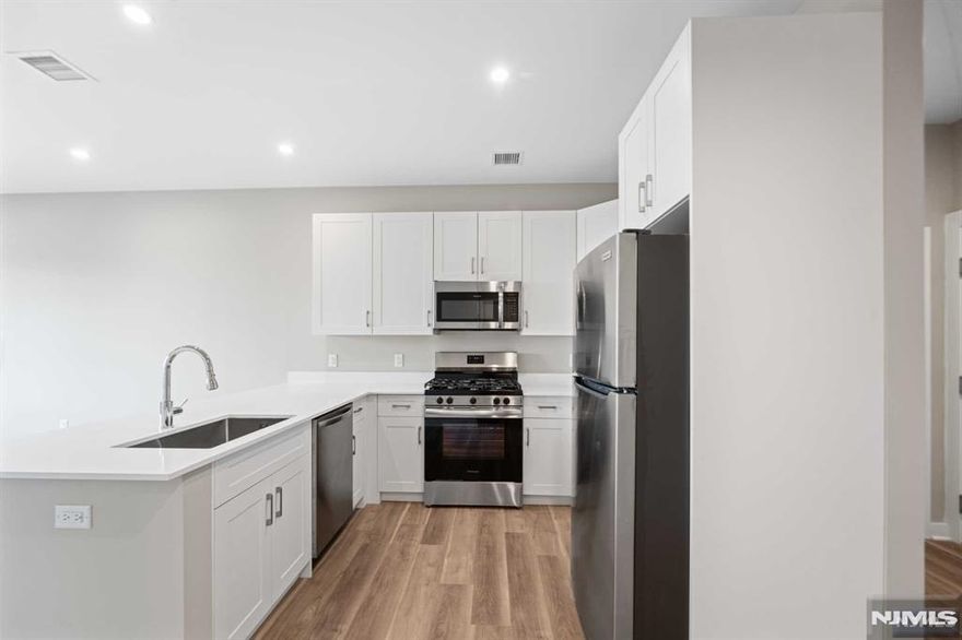 Unit 405 offers 845 square feet of thoughtfully designed living space, featuring a well-appointed one-bedroom, one-bathroom layout that blends comfort and functionality, along with a versatile bonus room perfect for work or personal use. The bathroom includes a bathtub and shower combination, creating a relaxing retreat. The kitchen is equipped with a high-end stainless steel Frigidaire appliance package, including a five-burner gas range with an oven, a microwave with an integrated exhaust system, a top-freezer refrigerator, and a dishwasher. A sleek quartz countertop peninsula doubles as a stylish breakfast bar, perfect for casual dining. Adding to the convenience, each unit comes with a full-size Samsung washer and dryer with a moisture sensor for enhanced efficiency.