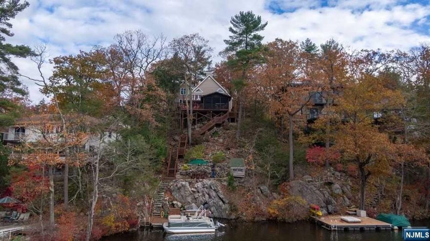 Stylish & elegant, this Glen Wild Lakefront is conveniently located just 30 miles from NYC. Renovated with a new roof in 2022, modern boiler/AC condenser/appliances/water treatment in 2020,hot water heater in 2023. Smart home features including switches, LED lights, high-efficiency DC fans, 3-zone thermostats, and smart lock. Enjoy breathtaking sunset lake views from the multiple decks and your sun-filled rooms featuring an abundance of oversized Anderson picture windows & doors with hardwood floors and high ceilings, including a vaulted 12ft ceiling in the living room with 84in fan and wood burning fireplace. Active & friendly lake community offers regular entertainment, events and activities like pickleball, volleyball, and a sailing & fishing club. Relax on the beach with staffed lifeguard or explore marked private hiking trails and nearby Norvin Green State Forest access. The property boasts a two-car garage and a semicircle paver driveway with plenty of additional parking.