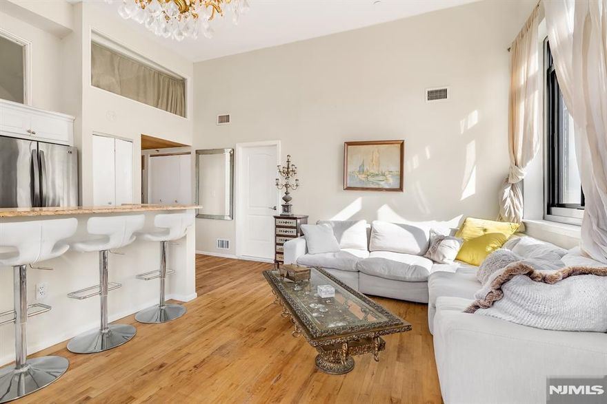 Contact/text Angela Cuciniello for Details 201.657-6084. Top floor Loft style 2 Bed 2 Bath condo meets urban Luxury Living in Prime Weehawken. Step into beauty in this inspiring coveted corner duplex Loft offering an open concept floor-plan with Artsy vibes. Boasting soaring 15+-ft ceilings, an abundance of natural light from oversized corner windows. The Chef's Kitchen features SS appliances, Quartz counters & Dining peninsula-ideal for gatherings & everyday alike. Elegant chandeliers add a touch of charm & sophistication to your living/dining space. This flexible layout offers 2 split Bedrooms, 1 on each floor providing ultimate privacy. Level 1 features loft space, configured as a 3rd guest bedroom w/ a desk. Possibilities abound customize to your own home office, Den. Tranquility awaits in the Primary Bedroom pictured w/ a King size bed, ensuite luxury marbled full Bath w/tub. The 2nd floor loft bedroom is enclosed w/ glass & inviting sitting area. A modern style luxury full bath oversized shower & chevron tile border is located off hallway. A combo w/d in unit. HOA inc: 1 garage parking; H/C Water; amenities, Pets welcome. Discover Gregory Commons Gated luxury condo complex. New hallway & common area renovations are in progress! Amenities: 24hr Concierge, Fitness, Indoor Pool; Sauna; Lounge; courtyard. A Commuter's Paradise-Only 2-Miles to NYC PA. Hassle free commuter options are 2 blocks away. Don't Miss out!