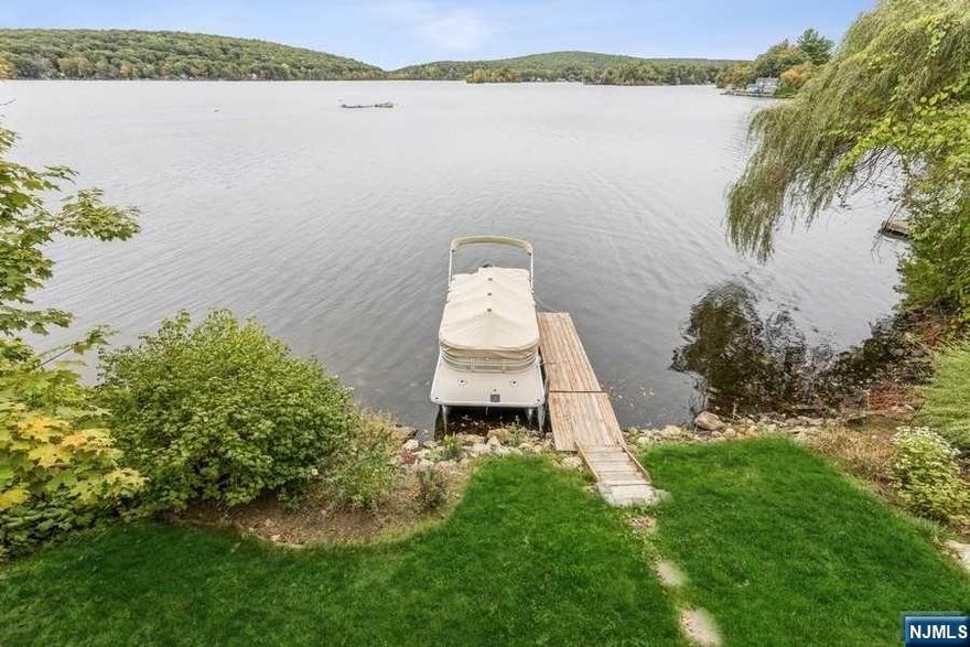 LIVE ON VACATION- Amazing opportunity to own this fabulous lakefront home! Make this your primary residence or your weekend getaway! This light, bright, open-floor plan 2 bedroom, 1.5 bath home boasts Upper Greenwood lake in your backyard and your own private dock. The main level of this beautiful home features your updated fully equipped kitchen with breakfast bar that flows to your living room with sliders to your large deck and a wall of windows for a spectacular panoramic view of the lake. A main level bedroom and full bath complete this level. Second level has a bedroom, a family room with a view and a full bath. The large unfinished lower level has sliders to your outside patio and access to the lake. So come enjoy this wonderful lake community lifestyle.