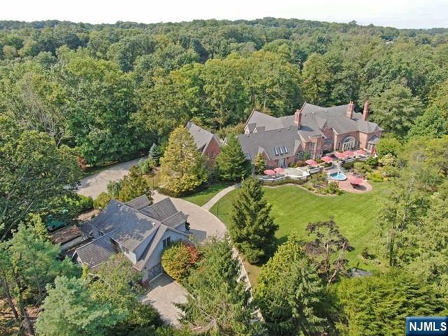 This elegant High Mountain Estate offers luxury, privacy, and tranquility minutes from NYC secluded on 6.5 acres, with manicured grounds & stunning acre of a koi fish lake, with fountains & bridge. Over 18,000 sq ft of luxurious living this Georgian Manor sits majestically overlooking the properties natural beauty, designed for maximum privacy with a double entrance & gates, featuring all year heated indoor pool with exercise jets, windowed fitness center, world-class lit tennis court, landscaped gardens, carriage house, gatehouse & 6 car heated garage with epoxy flooring. The classic architecture is notable by the custom millwork & coffered ceiling in the exquisite cherry library & throughout the estate. The Tuscan Style Kitchen opens to a two-story family ,dining area with 18' ceilings overlooking the pool and cabana. This one-of-a-kind estate is perfect for extended family, home office & separate private living quarters.