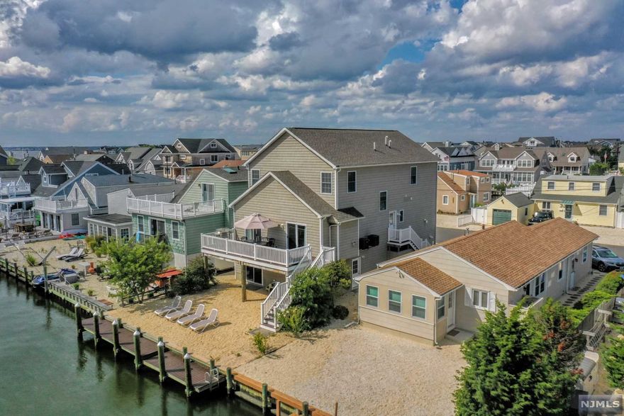 Newer waterfront 3-level home w/direct access to Barnegat Bay features 5BRs, 3.5B, open floor plan, custom kitchen, oversized breakfast bar, living area w/gas fpl, dual SGD to Trex deck. Also on main level: half bath, spacious owner's suite w/gas fpl, marble bath w/dbl sinks, SS, jetted tub. Upper level features four spacious bedrooms, large FB w/SOT, laundry room, Bessler stairs to full attic. Ground level features oversized 2C garage w/work and storage areas, programmable openers, FB w/SS, W/D, dining room w/wet bar & refrigerator, family room, dual SGD leading to expansive backyard, new Trex dock, and outdoor shower. Other features:3-level elevator, 30-yr. LVP flooring, high-efficiency HVAC, Certainteed siding, ceiling fans, ample off-street parking. Community offers bay/ocean lifeguarded swimming, kid's summer camp, basketball, pickleball, tennis, fishing/crabbing. As is-inspections for information only. Seller is licensed NJ Realtor