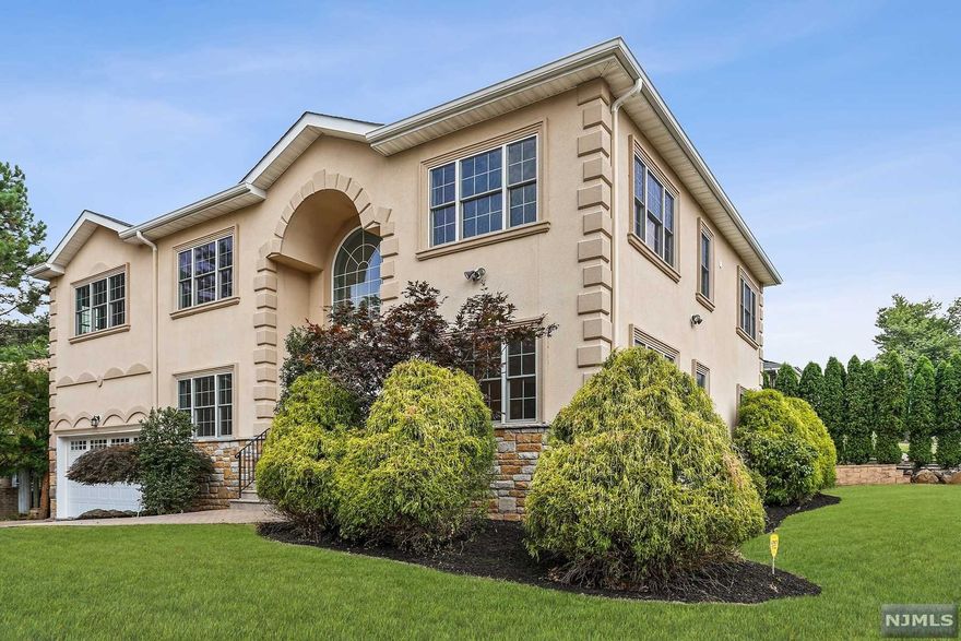 A Stately Stone/Stucco Colonial 5 BR/5.5 Baths.1BR w/full BA on 1st floor. Easy living with LR w/Gas FP, DR, EIK, Bkfst rm, Pantry, Laundry, PR all on 1st floor. Curved staircase to 2nd flr, w/2 story foyer. The kitchen has custom cabinets, GE SS appliances granite counters & Breakfast room. Family RM off the kitchen. Primary BR with sitting room, full bath, jetted tub, double sink, marble flr & countertop, walk-in closets, 3 additional BR's with attached full bath. Hardwood oak floors thru-out, 2 zone HVAC, Professional landscaping, u/g sprinkler system, security system, humidifier in 1,800 sf finished basement. 2 blocks to Jitney stop to South Orange train station to mid town direct trains. A coach bus is also nearby to NYC Port Authority. Partial NYC views from 2nd floor BRs.