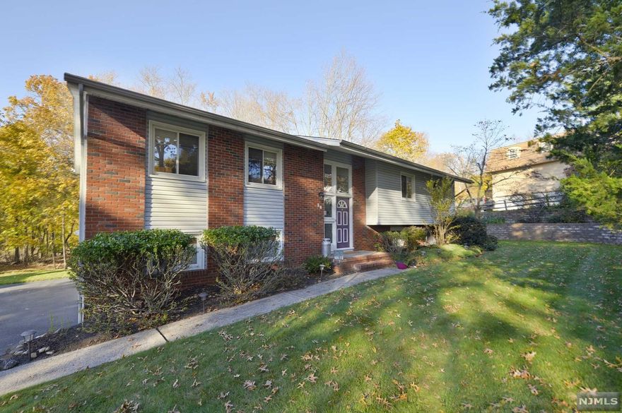 Wow! This Oversized Turn key Bi-level with Packanack Lake RIGHTS to membership is a must see! Updated throughout with new kitchen and bathrooms, this beautiful home sits on a lot steeped in tranquility and privacy! The unique spacious entry way invites you in to this light and bright oversized bi-Level boasting an open floor plan, smooth flow and spacious rooms; great for entertaining! Huge family room on lower level offers a wood burning fireplace and sliding glass doors to a patio. The 4th bedroom, laundry room, extra full bathroom and storage room complete the lower level. Newer roof, deck and hot water heater have all been replaced within the past 5 years. With no neighbors directly behind you, enjoy peace and quietude in this parklike setting. Pride of ownership is evident in this well cared for home, both inside and out. Truly a hidden gem!