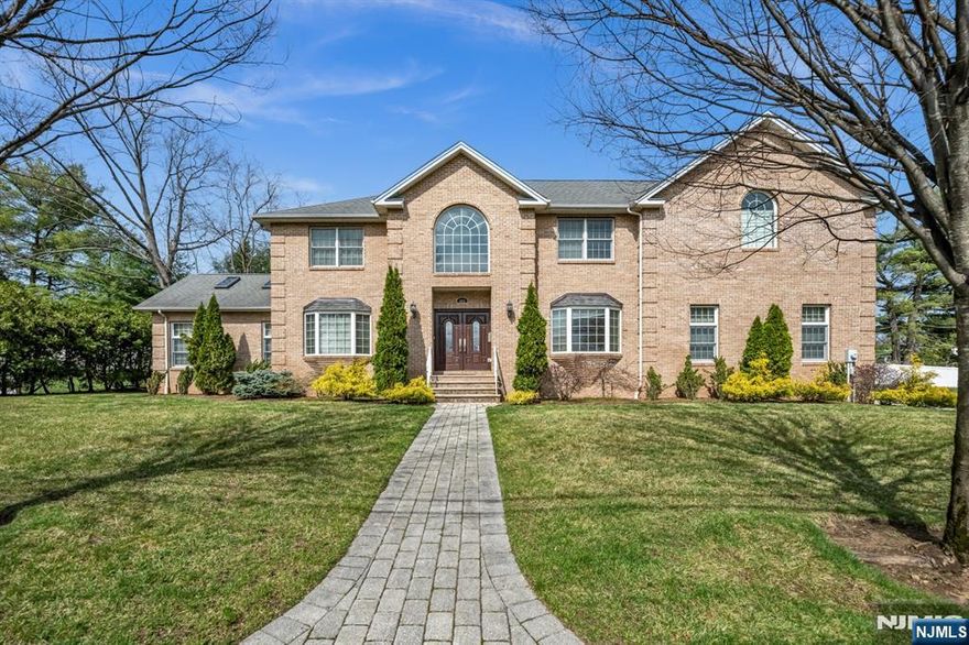 Stunning & grand center hall colonial with 4 bedrooms & 4.5 bathrooms. It features a 3 car garage and offers an extremely spacious and functional floor plan. The fully finished, amenity-packed basement was finished only 8 years ago and features two bonus rooms with closets(One is currently used as a gym). The main level welcomes you with a dramatic two-story entry foyer, flanked by formal living and dining rooms. A wet bar with beverage center and sink seamlessly connects the dining room to the kitchen, ideal for entertaining. The spacious kitchen features granite countertops, a breakfast nook, and opens to the expansive great room with vaulted ceilings and a gas fireplace. Upstairs, all bedrooms are generously sized with ample closet space. The primary suite is massive and offers two walk-in closets and a spa-like bath with a jacuzzi tub and oversized shower. A junior suite includes its own en-suite bathroom, while two additional bedrooms share a full hallway bath. A large laundry room completes the second level. Basement offers exceptional additional living space, including a large recreation room, bar, movie theater, gym, and a bonus room. Situated on a great property with a large deck and a flat, grassy backyard, this home offers both space and functionality. Ideally situated on a quiet cul-de-sac, walking distance to schools. Lot size is very large, approximately 12,824 sq ft. Paramus is known for top-rated schools, premier shopping, and a vibrant community.