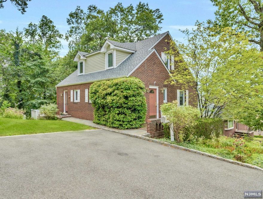 Charming all-brick colonial nestled on a quiet street in the beautiful hills of Ridgefield. This immaculately kept home features hardwood flooring, spacious rooms, and one of the best locations for New York City commuters seeking low Bergen County taxes and the perfect blend of suburban and urban living. Convenient full bath and bedroom opportunity on the first-level with a cozy living room with a fireplace and built-in cabinetry and shelving, formal dining room, full bathroom, and bright eat-in kitchen with entry from the large outdoor deck with picturesque Westerly views. Upstairs find the master bedroom with a full bathroom and two additional generously sized bedrooms. The walk-out basement is perfect as an extra living room or recreation space and includes an unfinished storage space. An ideal starter home and get away from city living close to everything-parks, schools, NYC transportation, shopping, and Palisades Park. Move right in!