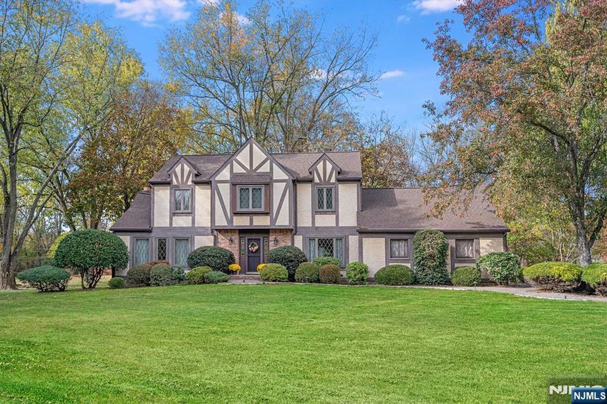 Classic Tudor charm set on nearly one acre in a sought-after Branchburg neighborhood. Lovingly cared for by the original owners, this spacious 5-bedroom, 2.1-bath home offers timeless character, beautiful curb appeal, and a warmth that is felt the moment you arrive. A welcoming foyer opens to a light-filled interior featuring two coat closets and formal living and dining rooms. The eat-in kitchen flows directly into the den with a gas fireplace, creating a comfortable space for everyday living. A rare first-floor bedroom offers exceptional flexibility for guests or a home office. Upstairs are four additional bedrooms, including a spacious primary suite with ensuite bath, walk-in closet, and a dedicated vanity area. Important updates have already been completed, including a new roof and siding (Aug 2024), refinished hardwood floors (2026), and a water heater (Dec 2025). The backyard is a standout, featuring unique park-like privacy, a rear patio, a two-car attached garage, and ample driveway parking. Ideally located just 0.6 miles from the elementary school, with easy access to major highways, shopping, and dining. The home is comfortably move-in ready while offering the opportunity to bring your own design vision over time - Welcome Home!