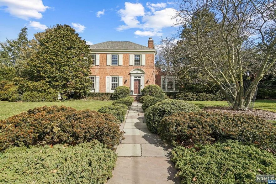 NEVER BEEN OFFERED... Nestled on a half acre, on the East hill of Tenafly, this picturesque ,all brick Colonial exudes timeless elegance enveloped by meticulously curated gardens. Boasting 3 Bedrooms, 2 full and 2 half baths, this residence blends classic charm with contemporary comforts. Features: Spacious Living rm w/ fpl with attached all glass porch, Banquet size Dining with abundant natural light, 1st floor office, which could lend itself to a playroom, extra bedroom, or den. The open kitchen floor plan is attached to a large, great room w/14 ft ceiling, including, Built-in, Architectural Cherry Woodwork, Beverage cooler, Wet Bar and access out to large ,brick Patio and 3 car attached garage. Offers: all Hardwood floors throughout, Exquisite moldings, 9 ft ceilings 1st Floor, Walkout basement w/ high ceiling, Tesla Charger,Copper gutters and so much more! 1 block from NYC Trans, close to places of worship and Blue ribbon schools makes this the perfect package. Wont last!