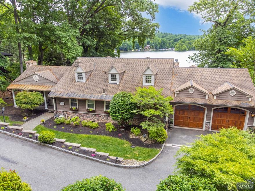 Pines Lake living at it's finest, walk out to your own private white sand beach and boat and ideal for extended living situation. "Staycation" at home with this unique lakefront resort style setting offering some of the prettiest long views of this clean, beautiful lake. This warm home has much to offer yet with expansion possibilities and an expansive yard with huge paver patio and elevated trex deck that are ideal for entertaining to enjoy lazy summer days. Major 2008 renovations include Brazilian Cherry and Walnut hardwood floors and custom molding throughout, center island kitchen w/granite countertops and stainless steel appliances with wet bar and wine refrigerator and opens to a sunny conservatory room with radiant heat, gorgeous new 1st floor master bedroom suite with vaulted ceiling and gas fireplace, 2 walk ins and full bath with steam shower and soaking tub. New siding replaced approximately 3 years ago, copper gutters & leaders in the front.