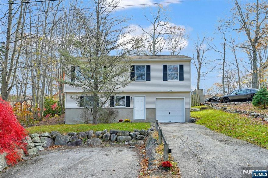 Incredible 3-Bedroom Bi-Level in Upper Greenwood Lake! Welcome to this bright and spacious home featuring a large living room with vaulted ceilings and hardwood floors. The updated kitchen with New Appliances opens to the dining room, creating a seamless flow. The main level offers 3 generously sized bedrooms with plenty of closet space. Downstairs, you'll find a versatile bonus room, perfect for storage, a home gym, office, or the ideal space to bring your vision to life. Additional highlights include a 1 car garage and a large, level backyard perfect for outdoor enjoyment. Located in a quiet neighborhood, this home delivers comfort, space, and convenience. Don't miss this one! With Optional Membership Granting Access To The Private Beach, Clubhouse, And Lake Amenities. Conveniently Close To Sussex County And The NY State Border, Enjoy Nearby Farms, Orchards, Hiking, Skiing At Mountain Creek, Wineries, Breweries, And Local Shops. Low Taxes - Schedule Your Private Showing Today!