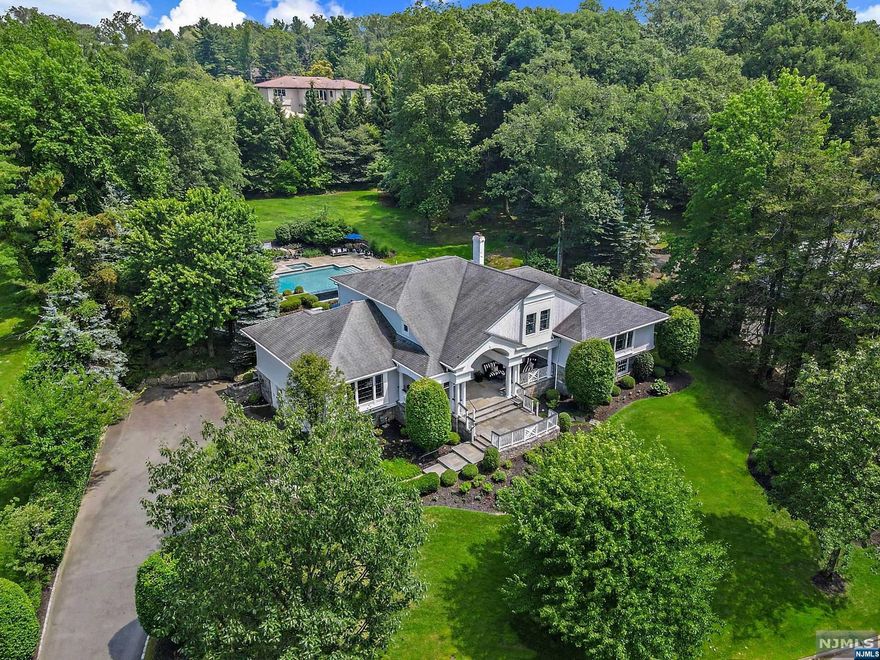 High on the exclusive east hill of Tenafly;exquisite updated Hamptons-style home on sprawling +/- 1.1 acre, w/spectacular gunite infinity pool & spa. The expansive stone patio boasts a fully loaded outdoor kit & the resort pool is sun drenched all day, w/sundeck, hot tub & in-pool bench.Boasting 5+ BRs, 5.5 baths & an amazing open floor plan.An elegant foyer spills into a spacious LR/fplc w/dbl glass doors to back yard,an oversized family rm is flanked w/windows & opens to a banquet size DR w/tray ceiling. The updated EIK is the heart of the home w/new quartz counters & backsplash & glass doors to the luxurious oversized patio. 2 bright & spacious ensuite BRs on the 2nd flr & 1 sundrenched lrg ensuite Bdrm on 3 lvl w/WIC & Bath/tub. A hotel like primary retreat is enhanced by the spectacular view from the wall of windows. The convenient mezzanine lvl w/full bth & access to back serves as pool cabana & offers office/bdrm & gym. Close to NYC, blue ribbon schools & lwr taxes.