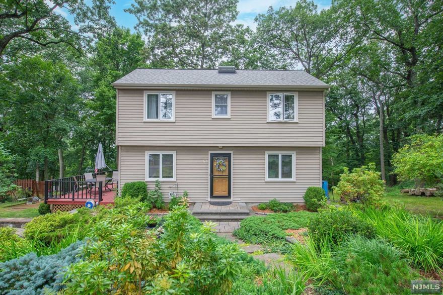 An oasis of peace, privacy & personality! Renovated, high efficiency Colonial situated on wooded, mtn top location, w/stunning views of forest & skies. Enjoy bright, spacious living w/the privacy of Bald Hill nature in Cedar Lake! This unique property offers a functional layout. 1st floor offers oversized LR w/fieldstone fireplace. Light, bright EiK w/propane gas cooking, ss appliances & a huge pantry. Large front room, 1st floor bdrm & laundry. Clean, updated main bath. Upstairs, 2 bdrms & bath. Supersized unfinished bsmt offers workshop, wb stove & plenty of storage. You will love relaxing & entertaining on deck & fenced in backyard! Professionally landscaped front gardens w/drip irrigation. Walk to hiking trails or Cedar Lake beaches! Easy Access to hwys& NYC direct transp. Denville living at its best!