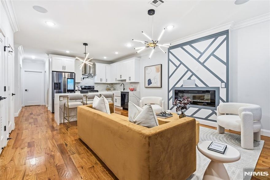 STR/AIRBNB APPROVED! This thoughtfully designed duplex condo offers a bright, spacious layout and an exceptional location in Jersey City Heights, just five minutes from the Journal Square PATH station and directly across from Pershing Field Park. The main level features a large living room filled with natural light from large windows overlooking the park. The open-concept kitchen is outfitted with sleek cabinetry, stainless steel appliances, and generous counter space. Two bedrooms are located on this level, including one with direct access to a private backyard that has been upgraded with Trex decking, stairs, and a pergola, creating a true outdoor retreat. The entire second level is dedicated to the primary suite, which includes a spacious bedroom with large windows, a separate office or den area, and a spa-like bath with double vanity, porcelain tile, and an illuminated defog mirror. A custom closet with sliding barn door provides added functionality. A fully finished 800+-square-foot basement with a full bathroom, offering flexible space for recreation, storage, or guests. Additional upgrades include a mudroom area by the entryway, a stair runner, and a whole-home surround sound and security system. EASY Street Parking -- Dedicated Space available if needed