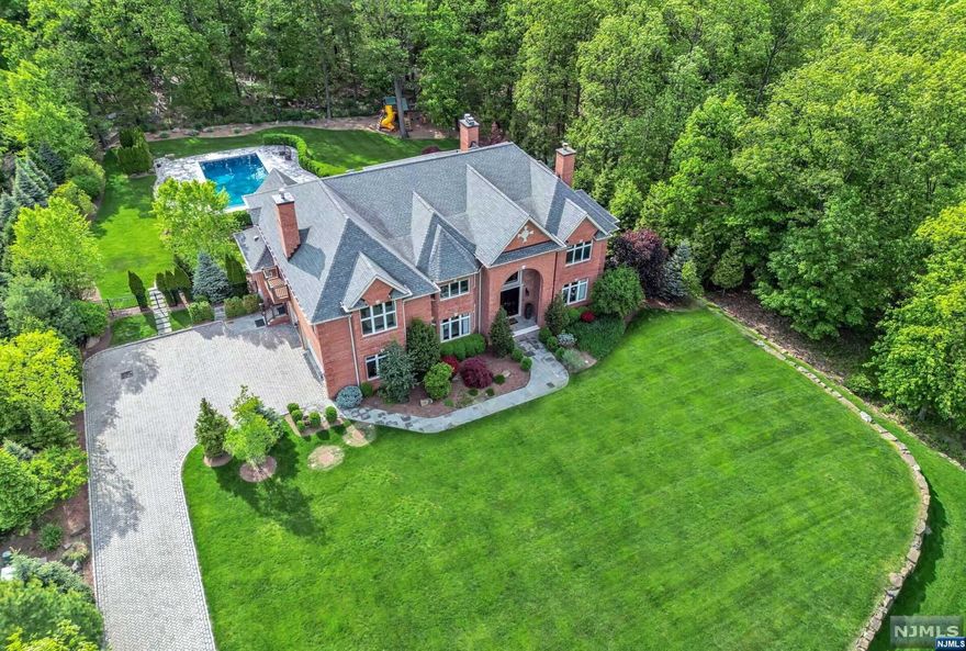 Nestled on a sprawling 2.3-acre estate enveloped by 700 acres of preserved land, this magnificent home epitomizes the pinnacle of luxury living. Crafted with meticulous attention to detail in 2016, this all-brick colonial blends classic architecture w/contemporary design, offering over 10,000 square feet of unparalleled elegance. Come home to the grandeur of iron gates leading down a private driveway, ensuring a rare sense of seclusion and tranquility. Step inside to discover a light-filled interior adorned with designer finishes and panoramic views. The main level boasts expansive open living spaces. Gourmet chef's kitchen ensures easy indoor and outdoor soirees. Upstairs, the lavish primary suite awaits, complete with extensive closets. Add'l ensuite br's provide comfort and privacy for family. Walk-out LL inc fam rm, bar/lounge w/wine wall, gym/br, full bth, rec rm, theater. Step out to an oasis w/ glistening salt water pool, lush lawns, covered and open patios. Must be seen!