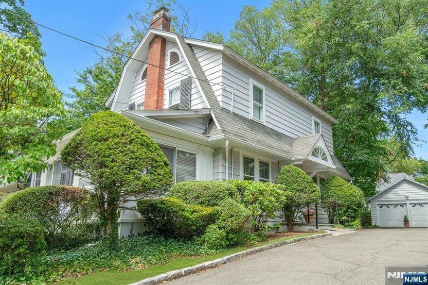 Character and charm abound in this traditional colonial. This home features living and dining rooms with soaring ceilings and gleaming hardwood floors, brick fireplace, and adjacent sunlit den. All white kitchen with tile flooring, half bath, side entry to yard. Second level offers three bedrooms, full bath, steps to attic. Lower level has playroom/home office and laundry. The lovely shady lawn shows many specimen plantings. Patio and garden enhance the landscaped grounds including two car garage. An exceptional home, close to everything, a true gem!