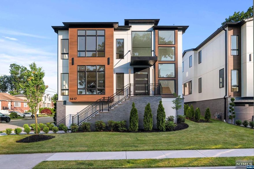 Indulge in luxury living with this brand-new masterpiece by a reputable builder on Fort Lee's sought-after street. A grand two-story foyer welcomes you with natural light and a 9-ft pivot door. Modern steps with glass railing lead to three bedrooms, each with en-suites and walk-in closets. Main suite boasts a spa-like bath, heated floors, and dual custom walk-in closets. Enjoy the convenience of a 14-ft laundry room with full cabinets. The open first floor layout includes a living room, dining room, bedroom/office with a full bath, and a custom chef's kitchen with high-end appliances, pantry, and an 8-ft island with a sink. The family room features a gas fireplace and built-in shelves. Step outside to a walkout paver patio and fenced yard. The ground floor offers a 2 car garage with EV Compatible Outlet, an 6 person movie theater, a spacious rec room with a wet bar, and a full bathroom. Elevate your lifestyle in this meticulously designed and thoughtfully crafted residences!