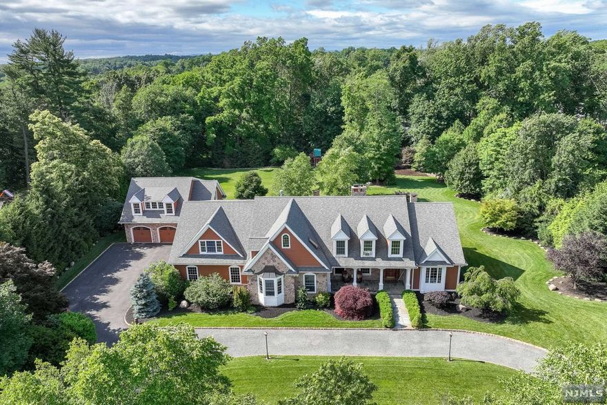 Builder's own home on almost 2 acres of park like property. Hand scraped hickory flooring & custom woodwork throughout, truly stunning home on a poured concrete foundation. No expenses spared. Bluestone porch, 2 story foyer & FR, kitchen w custom cabinets, granite counters & Viking appliances. Huge FR has massive Rumford fireplace, FDR, MBR has 2 WIC's a WBFP, french doors leading to patio, new FB with 2 person spa tub. 2 addl oversized BR's, FBTH, 1/2 BATH & a laundry room complete the 1st floor. 2nd floor has oversized BR with WIC in addition to unfinished area that could fit 4 more rooms and additional bathrooms. BSMT has 9 foot ceilings, craft room, office, FR w WBS, play room with WIC-custom shelving, pantry/gym, newer FB & storage. Sprawling paver patio w kitchenette & WBFP. 5 car garage, area over 2 car garage is ready to be finished into 1 BR apartment/in-law suite/ private office. Garages are a craftsmans/car enthusiast's dream. Alarm system-cameras, owner holds NJ LIC