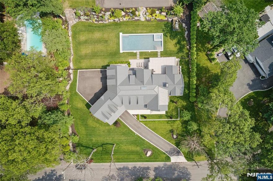 A rare gem in Tenaflyâ€™s prestigious East Hill, this breathtaking home sits on a full acre and offers every luxury amenity. Enjoy a private tennis court, pool, stunning loggia, and a wine room on the second floor. The design features soaring ceilings, floating staircases with glass railings, and an open floor plan with a sleek Italian kitchen. Upstairs offers six spacious bedroomsâ€”each with its own bathroomâ€”and a large playroom. The primary suite boasts a rooftop terrace, spa-like bath, and custom closets. All bathrooms are finished with floor-to-ceiling natural stone. The walkout lower level includes a massive recreation space, professional-grade gym, movie theater, steam shower, and abundant storage. A three-car garage and porte-cochère complete this extraordinary offering.