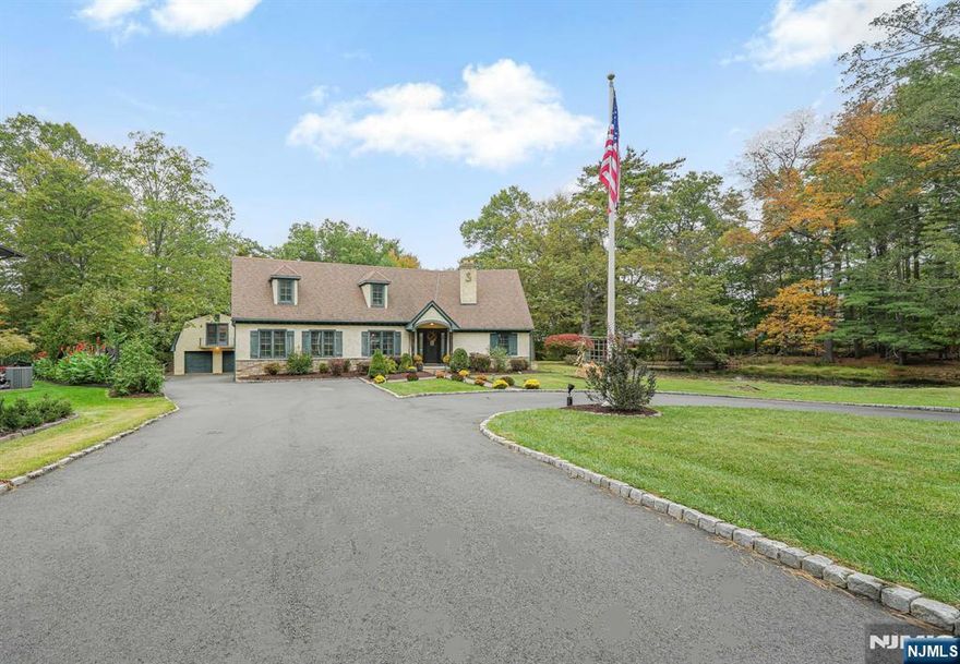 Stunning 4,200+ sq ft custom home set on 1.46 private acres with a pond and tranquil water views in one of Wayneâ€™s most desirable locations. Redesigned in 2007, this expansive residence can offer 6 bedrooms, 5.1 baths, and a flexible layout ideal for everyday living and entertaining. A grand foyer with sweeping staircase leads to a formal living room with fireplace and a dining room with butlerâ€™s pantry. Freshly painted foyer, hallways, dining room, and kitchen nook in a modern neutral palette create a bright, cohesive, move-in ready feel. The gourmet eat-in kitchen features a 10-ft center island, pot filler, walk-in pantry, and dining area that opens to a veranda-style patio with firepit and cafe lighting overlooking the flat backyard. The adjoining sunroom captures serene views and offers the opportunity for an open-concept design, as the wall between the kitchen and sunroom is a truss. The primary suite includes a gas fireplace, private balcony with water views, multiple closets including a walk-in, and a spa-like bath. Two additional bedrooms offer en-suite baths and walk-in closets. A private â€œgarage getawayâ€ provides guest or in-law quarters with separate entrance. Hardwood floors and 8â€“10 ft ceilings enhance the homeâ€™s scale and light. Located near top-rated Wayne schools, parks, shopping, dining, and NYC transportation.