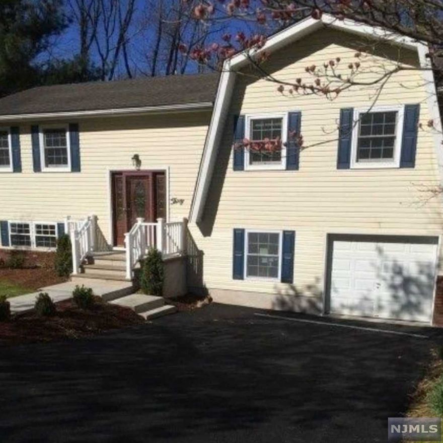 Rare find: picture yourself living in this beautiful bi-level in a sought-after section of Wanaque. Renovated in 2017. Hardwood floors throughout upper level. Lower level jackpot includes bedroom, full bath, family room, dedicated home office/den and laundry room.3 bedrooms on upper level, including primary bedroom with en suite full bath. Perfect for entertaining: the upper level boasts a renovated kitchen, wide living room, and dining room with sliders out to deck. Over 1/4 acre, with a spacious backyard. One car attached garage, driveway and easy on street parking for guests.