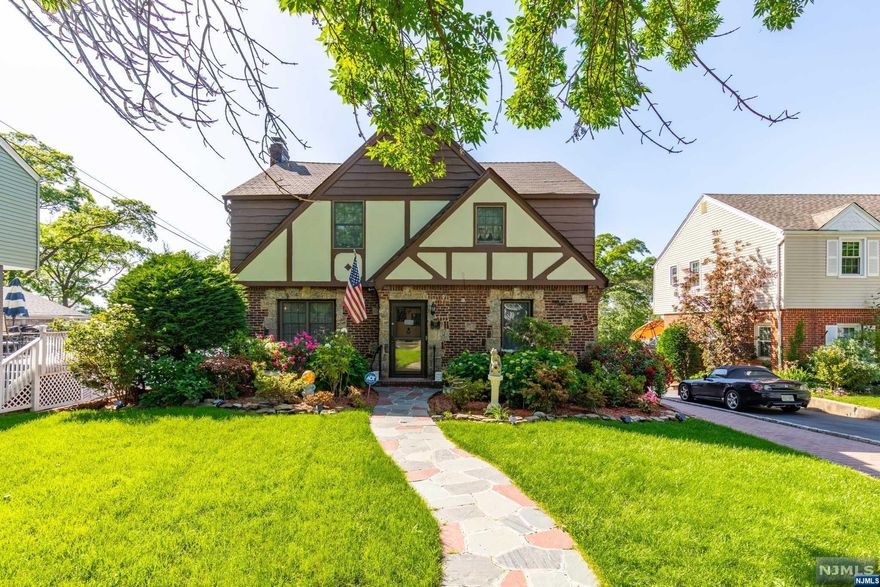 Welcome to this charming Colonial Tudor-style home in a desirable neighborhood of Rutherford. The professionally landscaped exterior provides a beautiful entrance to welcome you home. You can also park in the large driveway or 2-car attached garage to enter from the side or back of the house. Step inside and experience the spacious rooms, high ceilings and hardwood floors throughout this beautiful home. The main level features a formal dining room and large living room with wood-burning fireplace, perfect for hosting gatherings. An eat-in-kitchen with access to the backyard and powder room complete the 1st floor. The 2nd floor features a primary bedroom with full bath, two additional bedrooms, bonus room for home office, and another full bath. Huge finished basement with high ceilings adds more living space w/ a recreation room, full bath and laundry room. Enjoy the outdoor oasis with an inground pool and patio. Amenities include central air, sound, security and sprinkler systems.