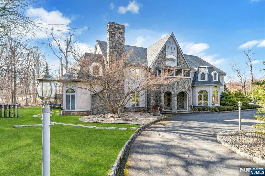 Custom-Built Stone & Masonry Stucco Tudor Manor, set on a prime, level, 2-acre lot, framed by mature landscaping, with serene garden waterfall koi pond feature and circular drive, located in the sought-after Burning Hollow neighborhood of prestigious Saddle River. This beautifully designed, 6BR, 6.2 bath spacious home features a grand 2-story marble entry foyer, 4 fireplaces, a huge sunlit great room with soaring 2-story vaulted ceiling, massive stone fireplace, and skylights, and a relaxing screened-in sun porch overlooking the park-like very private backyard. Richly paneled library/office with fireplace. Expansive modern eat-in kitchen with sliding doors to the large deck. Sumptuous primary bedroom suite with fireplace, sitting room retreat w/exclusive access to private enclosed balcony, 2 walk-in closets, and primary bath with sauna, steam shower and sunken tub. Exceptional functional floorplan with generously proportioned rooms, bathed in natural light. Third floor bonus hobby room. Full finished LL with spa room, bath, and more. Gorgeous custom Sylvan pool and spa, wrap-around flagstone patio, 3-car garage with lifts to accommodate 6 vehicles, newer roof and HVAC, the list goes on!