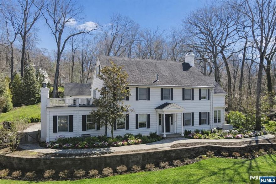 Set high on approximately 0.9 acres in Tenaflyâ€™s coveted East Hill/Old Smith neighborhood, this stately Center Hall Colonial blends timeless charm with thoughtful modern updates. A gracious entry foyer introduces a well-designed first floor featuring detailed moldings and hardwood floors throughout. A sun-filled solarium with walls of glass sits on one side, while a spacious family room with custom built-ins and one of two fireplaces anchors the other. The gourmet kitchen is equipped with stainless steel appliances and a large center island, ideal for everyday living and entertaining. The second level offers four bedrooms, two renovated baths, and a luxurious three-room primary suite complete with a spa-like bath. The third floor provides versatile bonus space suitable for a playroom, office, or additional living area. The expansive lower level presents endless possibilities for recreation or customization. A rare highlight is the detached two-car garage with potential for a second-floor home office or studio. The beautifully landscaped property features a large patio set within a serene, bucolic settingâ€”perfect for outdoor entertaining. A truly exceptional offering in one of Tenaflyâ€™s most desirable locations.