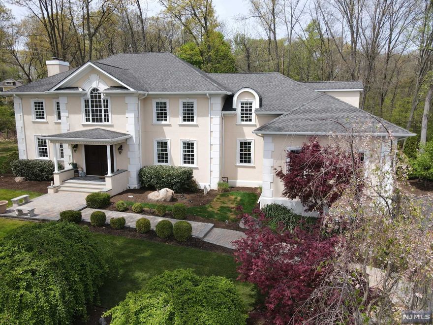 Hidden Gem! Tucked away on a nice sized (.8 acre) flag lot behind homes on Intervale Road sits this stunning stucco Center Hall Colonial. Quality craftsmanship, high-end features everywhere you look, this is a very special, quality home. From the minute you enter the 2 story foyer, you will notice the attention to detail in this home. Huge rooms, fine finishes, amazing entertaining space, this home was built with quality in mind. Gourmet kitchen with custom cabinetry, all high end GE Monogram appliances, tons of granite & imported tile, custom backsplash, 2 double ovens, utility sink in massive center island, pot filler on stove, large pantry, 2 built in wine fridges, this space makes a great hub for entertaining! Side by side living room & family room, each with their own back to back fireplaces. Gorgeous Primary Suite with huge walk-in closet & spa like bathroom. So many features! 3 car garage & huge unfinished basement with a separate area for wine cellar. All public utilities!