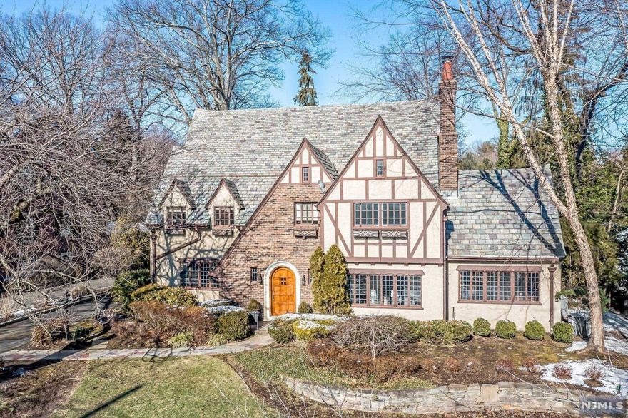 Beautifully updated home with a 4,600 SF interior (plus a finished basement) offering the perfect blend of traditional elegance and modern convenience. Situated in the prominent Ridge school district just minutes from NYC transportation and downtown, this Tudor is unique due to its bright and airy interior with high ceilings and large living spaces. Entry foyer welcomes you to a regal & functional floor plan featuring an impressive open staircase, inviting great room, eat-in kitchen with a sizable island and high-end appliances, and modern mudroom strategically placed at the rear entrance. Second level with 4 generous bedrooms and 5th BR suite/office on 3rd floor. Impressive basement featuring a gym and 400+ bottle temp-controlled wine room. Outdoor living space is just as grand as the interior, with a backyard that is 200 ft. deep, flat and private with a built-in outdoor kitchen/bar area & fire pit. The perfect home for entertaining on a large scale and everyday family living.