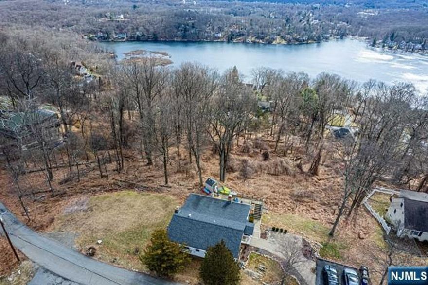 Impeccable Ranch w/stunning Lake & NYC Skyline Views surrounded by Jonathan's Woods which includes 635 protected green acres & hiking trails. Truly an oasis of peace & privacy located in the Cedar Lake section of Denville - truly unique & captivating property. OVER 1.2 acres on quiet, dead end street. ONE FLOOR LIVING. Significant & important upgrades made. Features include updated galley style kitchen with stainless steel appliances. NEW dishwasher & refrigerator. Separate dining area. Bright living room on the back of home. An abundance of windows throughout provide a beautiful ambience, tons of natural light & stunning views. Perfect for entertaining or relaxation! Enjoy the lovely & desirable Cedar Lake community- Clubhouse, beaches & boating! Tons of activities for all ages. Minutes to DWTN Denville-a vibrant DWTN with shopping, restaurants & events. Experience tranquility & privacy right in your own backyard w/all the conveniences of NYC mass transit & easy access to major hwys.