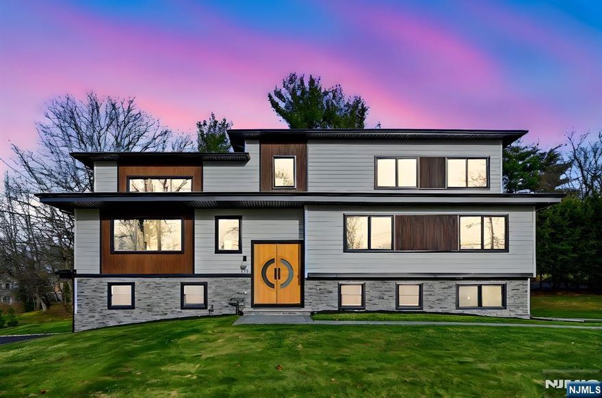 This one-of-a-kind, bold statement home is architecturally unique, blending modern design, craftsmanship & luxury. Set on an exceptionally large, flat lot in the prestigious Deerfield section, offering sweeping sunset views from most windows throughout the home. A custom Mahogany & White Oak entry door opens to a dramatic foyer with natural black stone tile, glass walls & designer lighting. The striking 18-foot great room features wide-plank 7 white oak floors, a floor-to-ceiling fireplace with gold accents, recessed lighting & custom black Andersen 400 windows. Expansive glass sliders lead to an oversized Trex deck with fiberglass waterproofing designed to support a hot tub, overlooking a pool-ready backyard. The chef's kitchen offers custom Woodmark cabinetry, a quartz center island with dual-sided seating, ZLINE black Autograph Edition SS appliances, gold hardware & metal backsplash. With 3 full levels of above-ground living, the home offers exceptional flexibility. 8 bedrooms include an upper-level primary suite with a spa-style wet room, two-person jacuzzi, body-spray shower & floating vanities. The bright walk-out lower level is ideal for work-from-home living, featuring luxury vinyl flooring, laundry, private bedrooms, two separate exterior entrances, and a covered patio below. Exterior highlights include a custom flat roof, professional landscaping with 80 Green Giant arborvitae, 2 new driveways, an oversized garage with polyaspartic flooring & smart-home features.