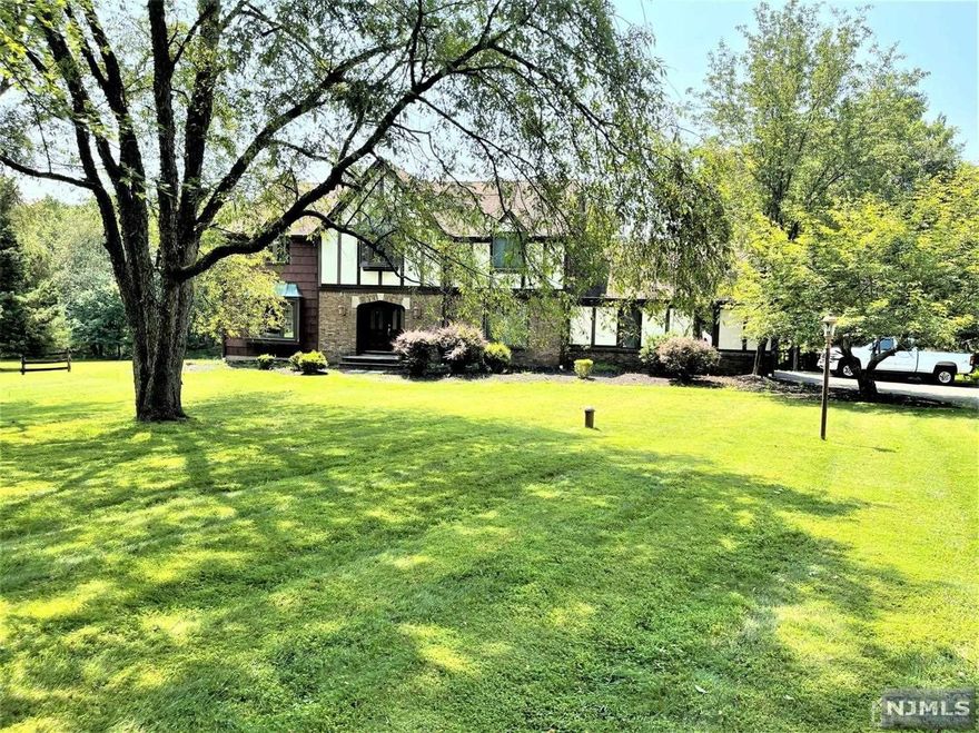 Spacious Tudor style custom colonial in one of Readington's most desirable areas. Newer kitchen with granite counters, center island, maple cabinets, newer stainless steel appliances. Hardwood floors in entire home. Freshly painted. Formal dining room. Enormous 1200 sqft deck in rear overlooks a beautiful stone patio that leads to the inground pool. Wood burning fireplace in family room. Full finished basement with office. Expansive yard with beautiful landscaping. Updated bathrooms. Property priced to sell as-is.