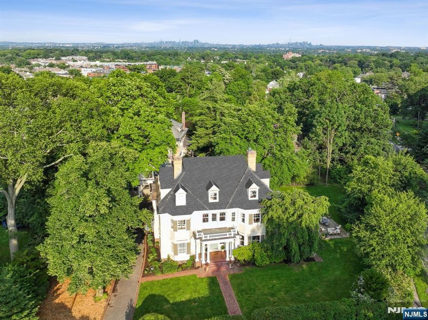 Welcome to a true architectural gem where history, craftsmanship, and location converge. Set on over 2/3 an acre just a few blocks from vibrant Downtown Montclair, this 1905 Colonial Revival stuns from the start with its Corinthian-columned front porch and original Dutch door, an elegant prelude to the timeless beauty within. Lovingly restored over the years, the home retains a remarkable array of period details: tiger oak floors, stained and leaded glass windows, working pocket doors and seven fireplaces, each with its own unique mantel - none more exquisite than the hand-carved oak surround in the gracious living room. The formal dining room, complete with its own hearth, sets the scene for unforgettable gatherings sets the scene for unforgettable gatherings. With over seven bedrooms and five full baths, three of them en-suite, this home offers room to grow, create, and dream. With initial zoning approvals in place, the possibilities extend even further with the magnificent three-bay, cross-gabled, two-story carriage house at the rear. It offers endless potential for additional living space, an art studio, a place to house your car collection and/or guest quarters. Just 0.7 miles to the Bay Street train station & steps to Montclair's beloved shops, restaurants, arts scene & farmers market, this one-of-a-kind property pairs the soul of an heirloom home with the convenience of city-suburban living. A rare and wonderful opportunity to become a steward of Montclair history.