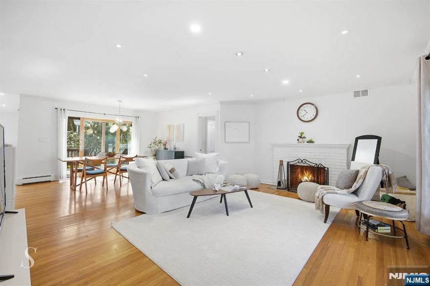 Presented by Sarah Chung (201.788.9901). Set on a tree-lined street in desirable Fair Lawn, 5 Franciscan Way is a classic brick residence offering timeless character, thoughtful updates, and an exceptional lifestyle. Curb appeal abounds with manicured landscaping and a paver driveway leading to the attached 1-car garage. Inside, a sun-drenched open-concept layout unfolds effortlessly â€” the spacious family room, elegant dining area, and gourmet kitchen flow together in perfect harmony. Abundant natural light pours in through oversized windows and sliding glass doors, while a cozy fireplace anchors the inviting family room. The chef's kitchen impresses with rich cherry cabinetry, granite countertops, a center island with gas cooktop, and premium stainless-steel appliances, opening to a stunning vaulted sunroom crowned by skylights. Four generously sized bedrooms and two beautifully appointed full baths â€” including a jetted soaking tub â€” provide comfortable retreats. Upper-level bedrooms feature charming cathedral ceilings and serene treetop views, adding warmth and character throughout. Step outside to the expansive deck and fully fenced backyard â€” your private oasis for entertaining or quiet relaxation. Ideally located near top schools, shopping, dining, and effortless NYC commuting via NJ Transit bus and train. Welcome home.