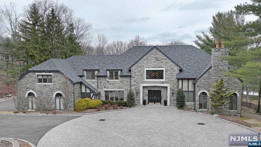 Impressive stone front Manor on one of Franklin Lakes most desired streets! Almost 2 acres of private, tranquil property. Newer 6 BR Septic! Exquisite features inside & out, include a custom inground pool w/rock waterfall, outdoor hot tub, & large custom patio overlooking the expansive rear lawn. Beautiful curb appeal set back almost 150 feet! New large circular front paver driveway for multiple cars & guests at all times. Stunning interior design incorporates a breathtaking 2 story entrance foyer w/bridal staircase to galley overlooking the magnificent Great Room & bar w/exposed beams & dramatic floor to ceiling rock fireplace! Large open kitchen is perfectly situated & the floor plan makes this a perfect house for entertaining! 1st flr home office & family rm - both could be 1st flr BRs - living rm, 2 powder rms & convenient laundry rm. 2nd flr houses 4 BRs. Primary Bath cleared to studs ready for new buyers design! See Fact Sheet for more features! Must See Video Tour!