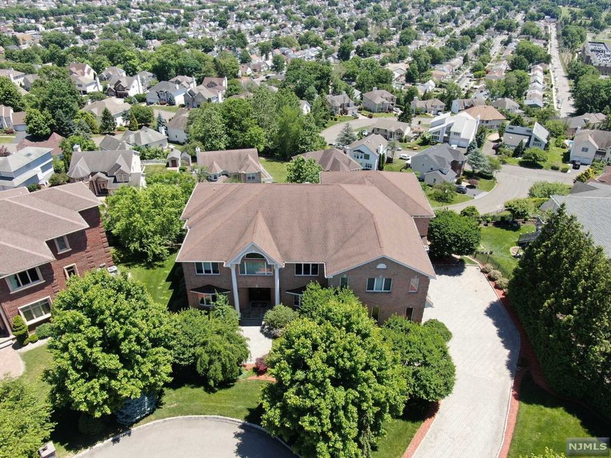 Pride of ownership! Meticulously kept all brick colonial nestled along a top street in town. Breathtaking skyline views! Showcasing six bedrooms each w/en-suite baths. Gourmet Chef's kitchen w/professional appliances, center island with raised breakfast bar and granite and stone tile work. Complete attention to detail throughout, approximately 11,000 square feet of Luxury Living inclusive of finished walk out lower level. Additional features include a spacious open floor plan for entertaining, dramatic entry foyer with sweeping staircase, conservatory, 3 verandas, 3 master suites on 2nd floor; 5 bedrooms total each with en-suite baths on 2nd floor, main floor bedroom/office with full bath, hardwood floors, recessed lighting and crown throughout, 3 gas fireplaces, detailed stonework in each bathroom. Full finished lower level that is an extension of main level with full bath and wet bar, custom landscaping and 3 car oversized garages. This is not one you want to miss.