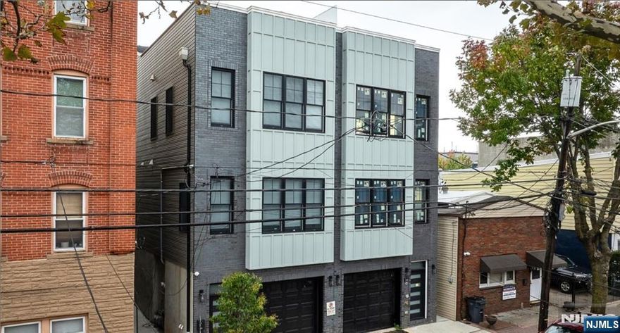 Modern Luxury Meets Urban Convenience at 40 Wright Avenue, Jersey City. Built in 2024, this newly constructed residence offers contemporary design, high-end finishes, and energy-efficient systems throughout. Sun-filled interiors feature an open-concept living and dining area with high ceilings and expansive windows. The chef-inspired kitchen is equipped with quartz countertops, custom cabinetry, and premium stainless steel appliances, seamlessly blending style and functionality. Spacious bedrooms provide ample closet space, while designer bathrooms showcase sleek tilework, floating vanities, and spa-inspired finishes. The primary suite includes a walk-in closet and private en-suite bath, creating a comfortable retreat. Enjoy the confidence of new construction with all-new electrical, plumbing, HVAC, insulation, and modern structural systems. A rare deep tandem garage offers potential space for multiple vehicles plus additional storage. Located on a quiet street just minutes from Journal Square, PATH, light rail, major highways, dining, and shopping, this home delivers both tranquility and unmatched accessibility. A move-in-ready opportunity combining modern elegance with everyday convenience.