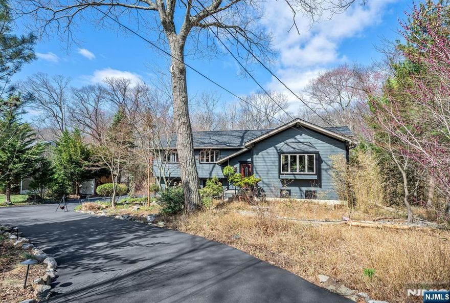 Spectacular, one-of-a-kind home with an upscale flair far from typical! This unique property features an elevated living room w/vaulted ceiling, filled with natural light and designed for open, airy living. A few steps up, the formal dining room impresses with high ceilings and sliding glass doors leading to a deck overlooking a serene backyard perfect for indoor-outdoor entertaining. The exceptional kitchen is anything but ordinary, Showcasing a large center island w/ honed travertine & seats 4, endless cabinetry, granite countertops, & an oversized 6-burner stove with griddle & hood vent - a dream for everyday living, gourmet cooking & entertaining. A large bay window allows for beautiful natural views while you cook & gather. This level offers three spacious bedrooms and an updated full bath. The lower level adds even more living space with an industrial-style family room featuring a waxed cement floor, open beamed ceiling, and a wood-burning brick fireplace, 4th bedroom / office w/full bath & walkout to patio, large media / bonus room, powder room & laundry complete the space, plus Sliding glass doors leading to a large composite deck ideal for hosting or relaxing. 2 car garage. Additional highlights include a circular driveway with plenty of parking, maintenance-free landscaped front yard means no lawn mower needed, Hardy plank siding, newer Andersen windows, new C/A Private rear yard. prime location close to shopping, restaurants, parks, & NYC Express bus