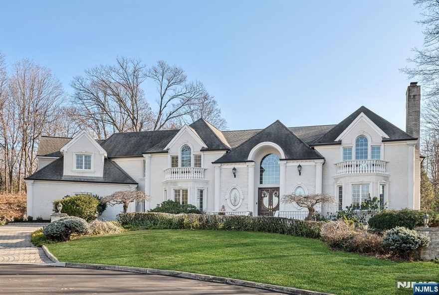 Discover unparalleled luxury and refined living in this exquisite custom-built all-brick home, perfectly situated at the end of a premier cul-de-sac on 1.4 lush, private acres. Designed by the renowned Leonard Divak, this 6,600+ sq. ft. residence effortlessly combines timeless elegance with modern comfort and warmth. Step through the grand entryway, where soaring ceilings and breathtaking bridal staircase create an unforgettable first impression. Entertain in the banquet-sized formal dining room with butlerâ€™s pantry and gracious living room with cozy fireplace. The homeâ€™s perfectly flowing floor plan continues with the gorgeous chefâ€™s kitchen, highlighted by granite counters, custom cabinetry, stainless steel appliances, and a spacious center island. The kitchen opens seamlessly into the dramatic great room, showcasing 20-foot ceilings, a wet bar, and an impressive fireplace. A first-floor office with a full bath offers flexibility as a guest suite/bedroom. A family/media room, mudroom with laundry, and 2 powder rooms complete the main level. Upstairs, the primary suite serves as a luxurious retreat, featuring a tray ceiling, two spacious walk-in closets, and a spa-like bath with a double vanity, soaking tub, and separate shower. Three additional generously sized en-suite bedrooms and a balcony overlooking the great room complete the second floor. The beautifully landscaped backyard offers a private oasis, featuring a spacious patio, built-in BBQ, 2 retractable awnings,