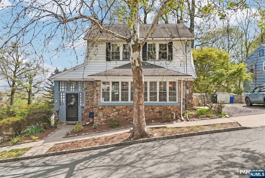 Amazing opportunity to own this 5-bedroom, 3.5-bath Colonial in sought-after West Orange. Upon entry, you're welcomed by an enclosed porch area, perfect for your morning coffee. This home features beautiful hardwood floors throughout, a spacious updated kitchen with SS appliances, & a formal dining room perfect for entertaining. The inviting living room features a fireplace & opens to a sunroom, ideal for a home office. A convenient first-floor powder room adds to the home's functionality. The first-floor primary suite provides comfort & convenience with its own en-suite bath. Upstairs, you'll find three additional bedrooms & a beautifully renovated full bath. The finished basement adds exceptional versatility with a fifth bedroom featuring its own private entrance, full bath, kitchenette, tv room, washer & dryer, & plenty of storage. A unique bonus space reported by the previous owner to have once been a speakeasy offers endless possibilities for a media room, game room, bar, or recreation space. Enjoy the expansive patio, perfect place to BBQ and entertain, with seasonal views of the NYC skyline. The property also includes a 2-car attached garage. The backyard offers a unique outdoor setting with a deck off the kitchen, a garden area and a separate space well-suited for a dog run. Commuter-friendly location with Jitney service to NYC train. Conveniently located near Montclair, with its vibrant shopping, dining, & entertainment options.