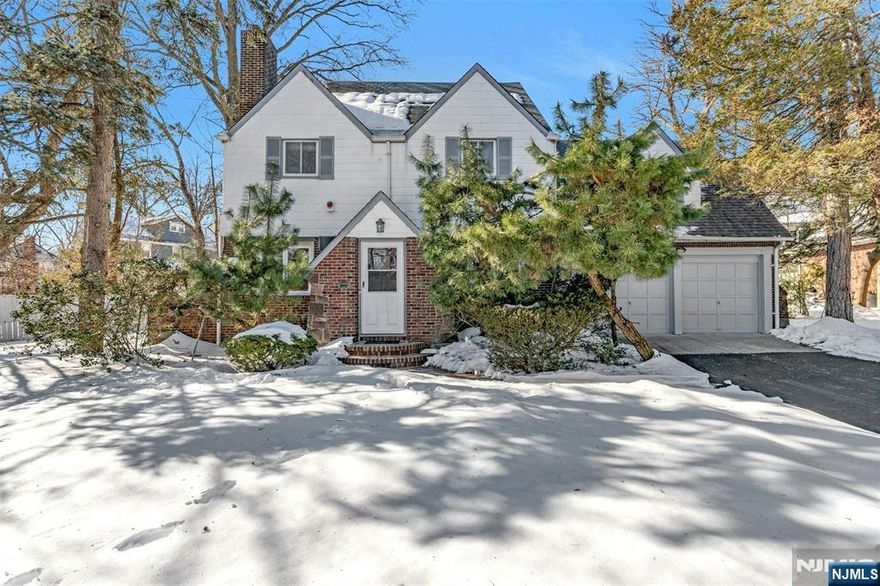 Tucked away on an exclusive private cul-de-sac with only two residences, this distinguished Tudor Colonial offers rare privacy, timeless architecture, and exceptional versatility. The main level features an expansive living room with fireplace, a formal dining room, and a vaulted-ceiling family room with direct access to the deck and yard. The modern eat-in kitchen and powder room complete this level. The second floor offers a spacious primary with en-suite bath, two additional generously sized bedrooms, and a full hallway bath. The finished third floor provides a flexible fourth bedroom or office, along with abundant storage. With either access through the kitchen or through a private separate entry the lower level can be either a professional office suite complete with a full bath, fireplace, and wet bar or a wonderful area for family entertainment. Additional highlights include central air, a whole-house generator, room for future expansion, and a two-car attached garage. Ideally located close to NYC transportation, Holy Name Hospital, houses of worship, schools, and shopping.